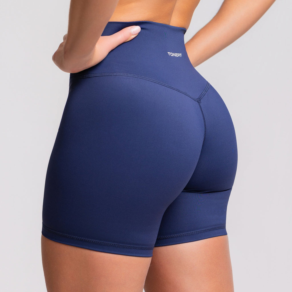 Front view of woman wearing TONEFIT V-Waist 5" shorts in Deep Sapphire color
