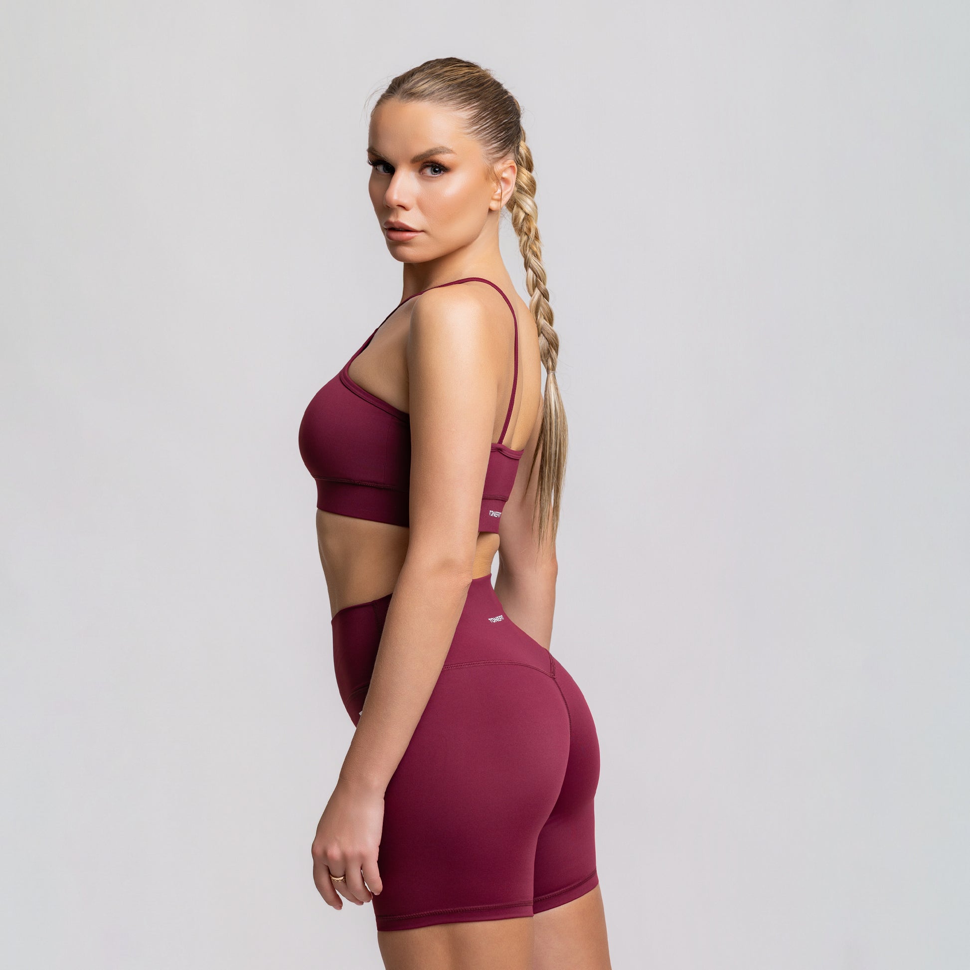 TONEFIT women’s 5-inch V-waist Dark Plum shorts back left angle showing sculpted fit and supportive waistband