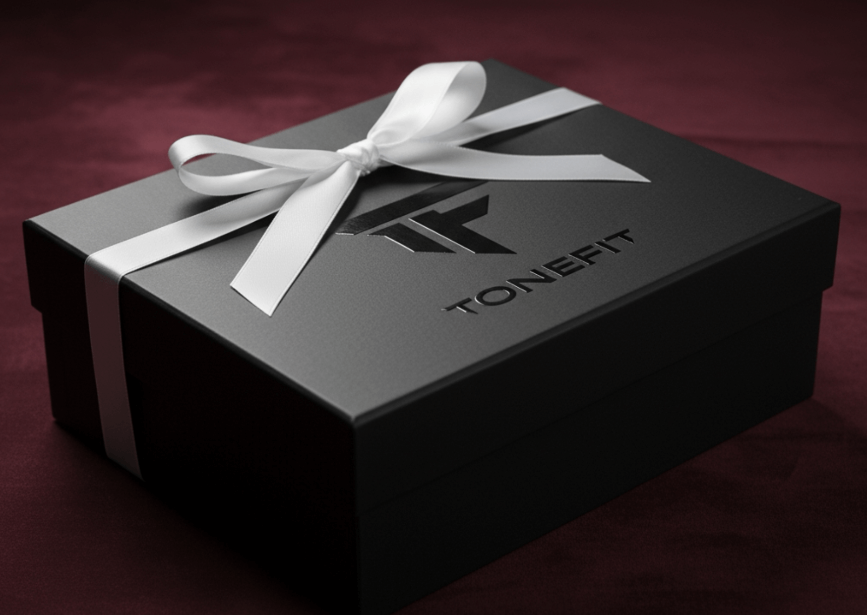 Digital fitness gift card presented in a sleek black gift box with a white ribbon, branded with TONEFIT logo.