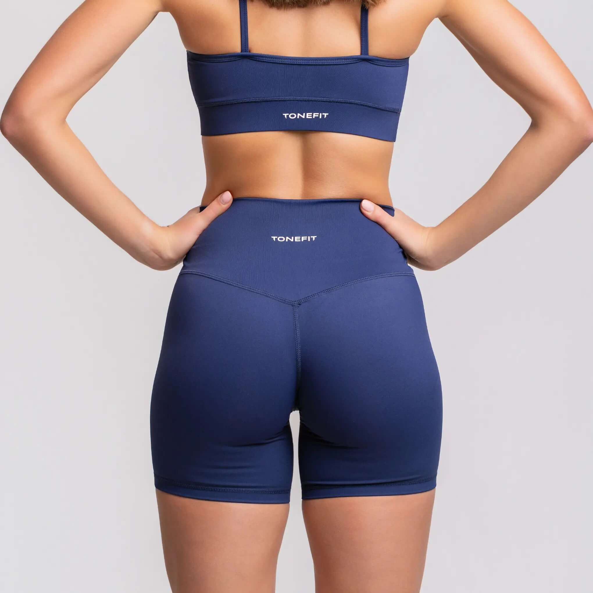 Back view of a model wearing TONEFIT 5 inch inseam gym shorts, showcasing the precision sculpting feature for enhanced support.
