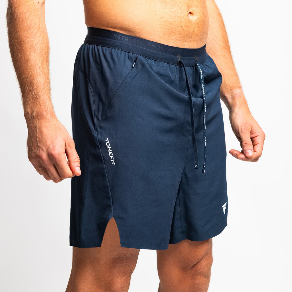 Side angle of TONEFIT men’s dark sapphire athletic shorts showcasing side slit detail.