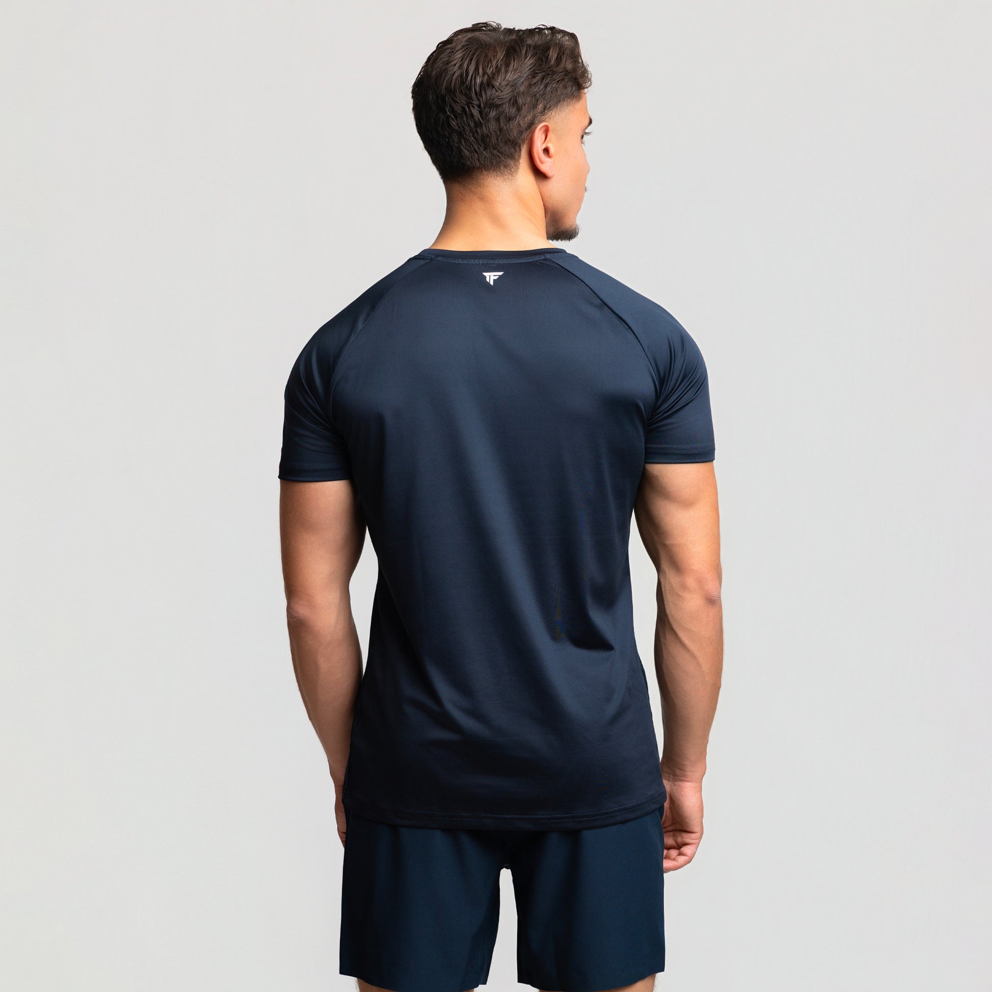 Back view of TONEFIT men’s dark sapphire athletic t-shirt with tonal logo and flexible fit.