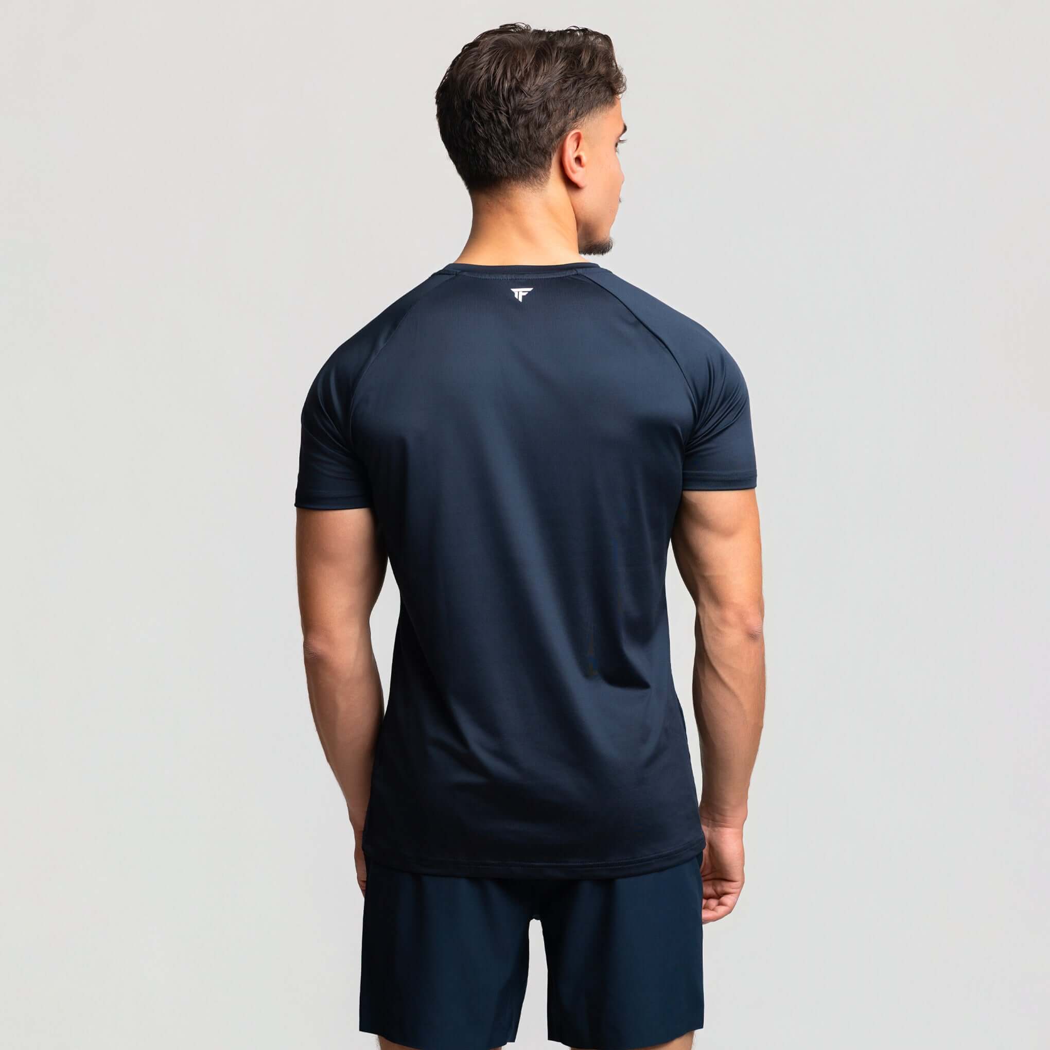 Back view of a man wearing the Kinetic Raglan athletic fit gym shirt, showcasing its seamless design and athletic fit.