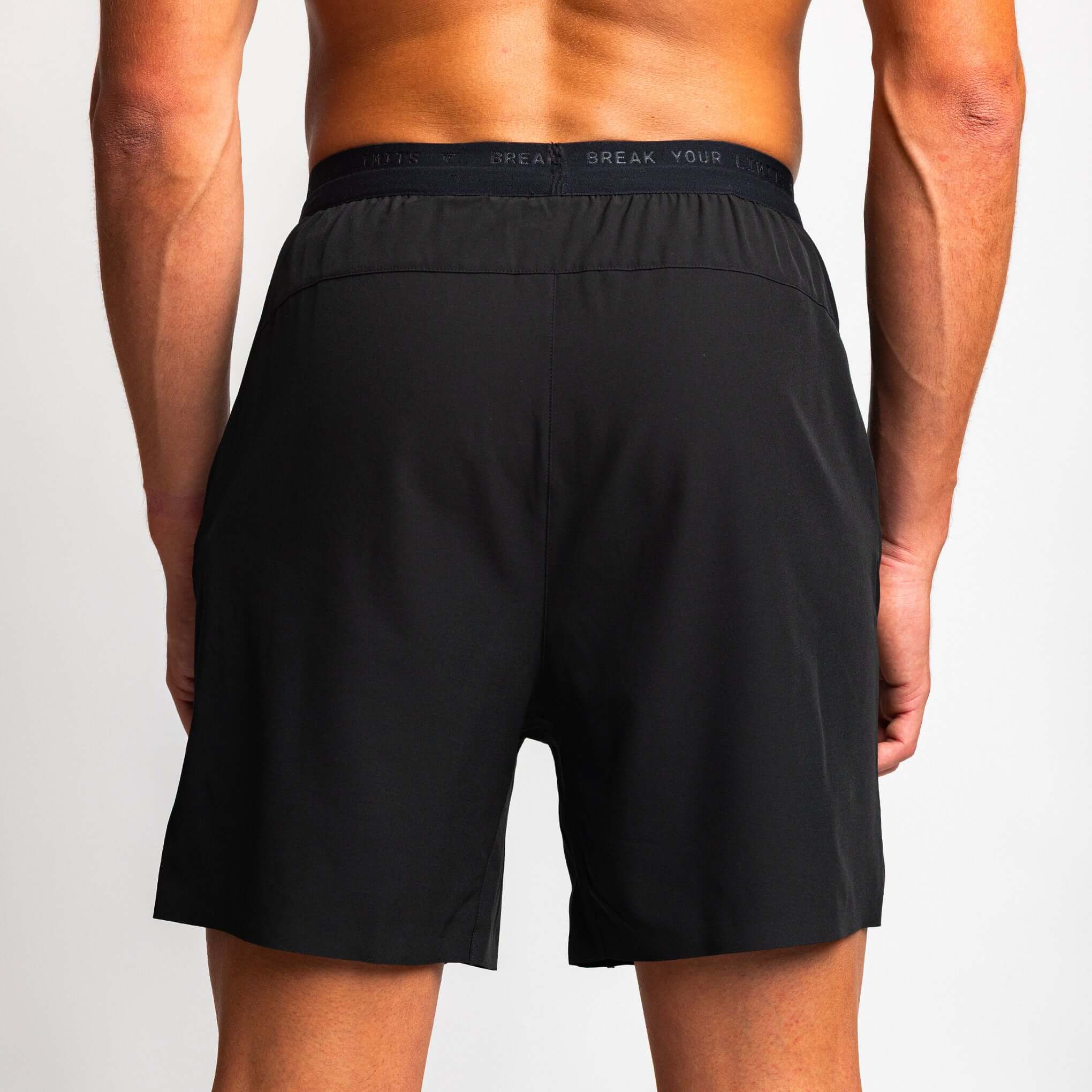 Back view of a man wearing 2-in-1 hybrid training shorts, showcasing the sleek design and comfortable fit.