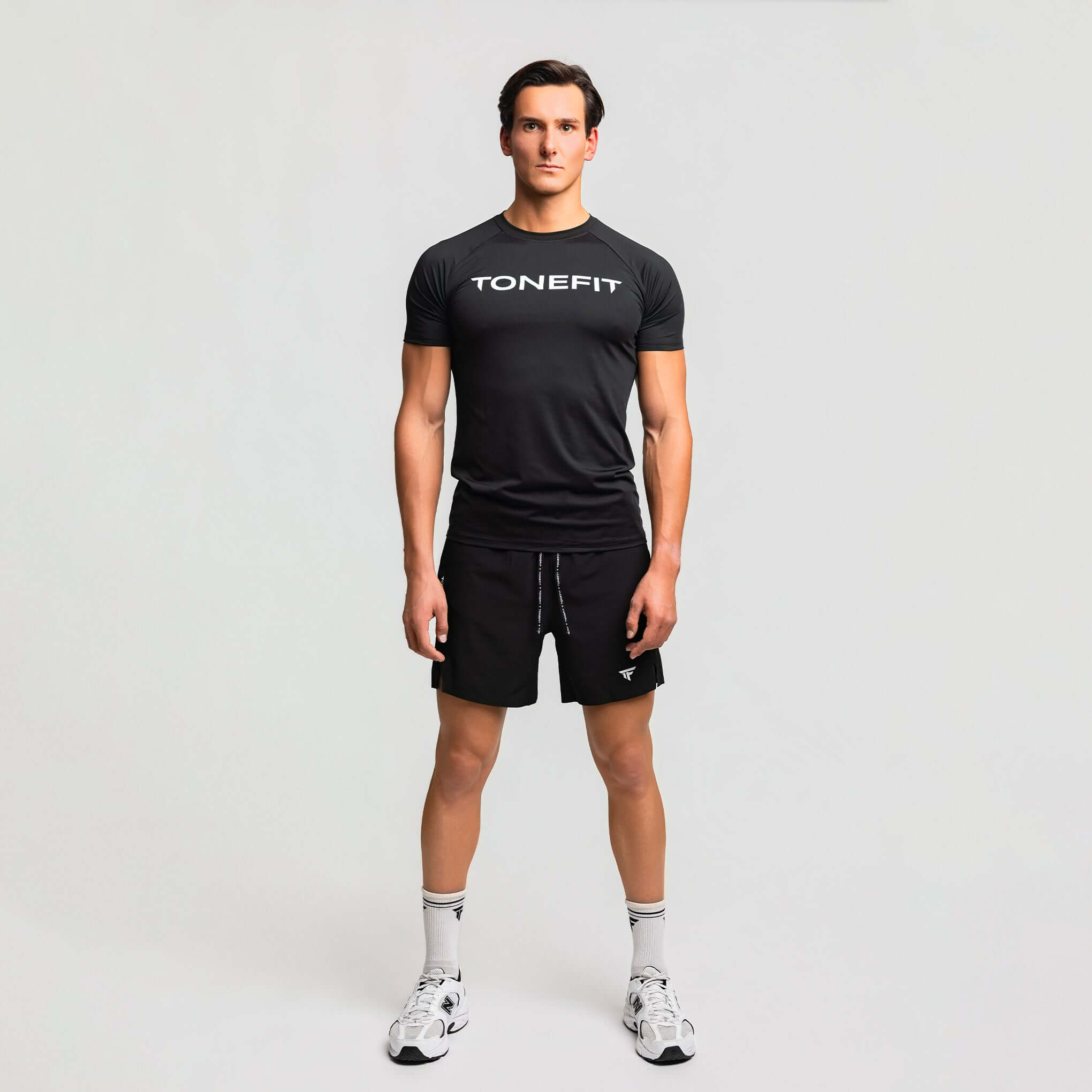 Model wearing Men's 6 inch training shorts from TONEFIT, showcasing high-performance versatility for workouts.
