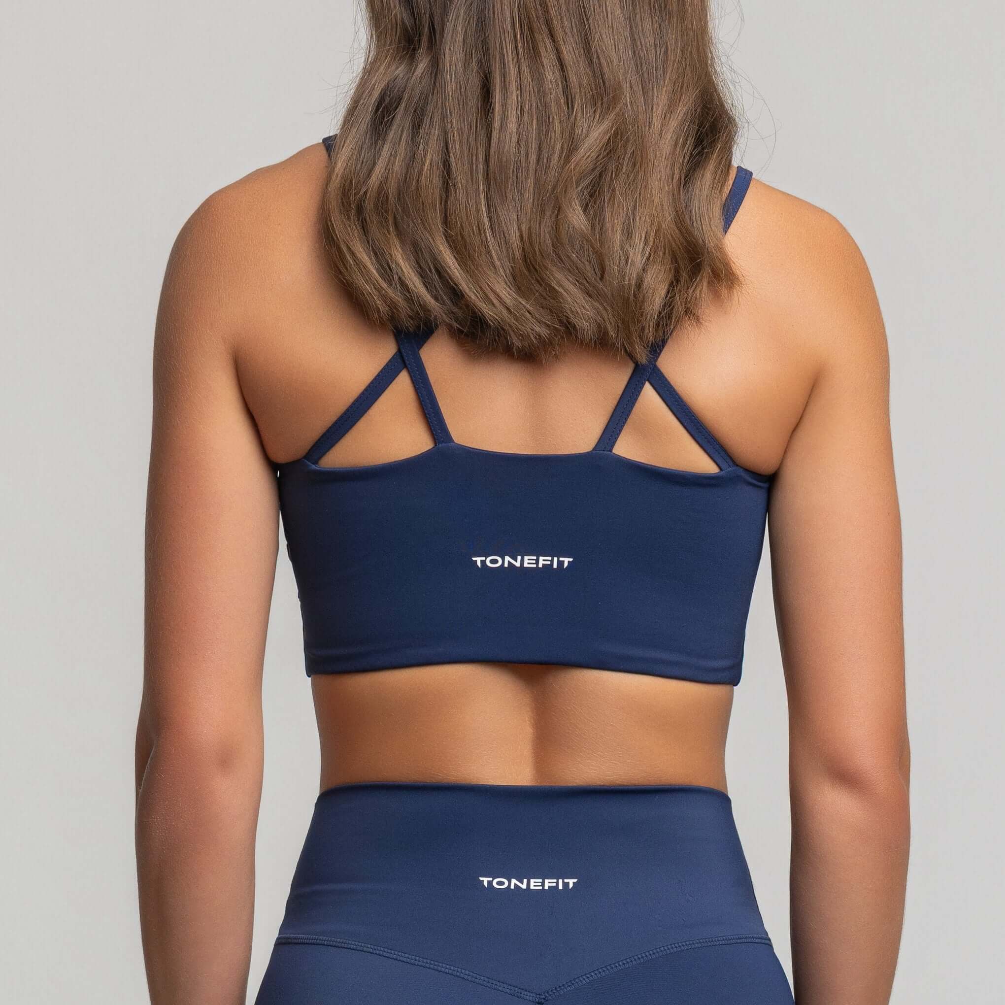 Back view of criss cross back sports bra by TONEFIT showcasing dynamic design and support.
