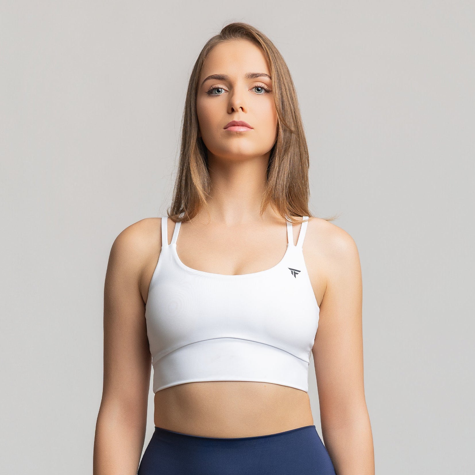 Front view of TONEFIT women’s Criss-Cross Strappy Bra in white with scoop neckline and clean-fit band
