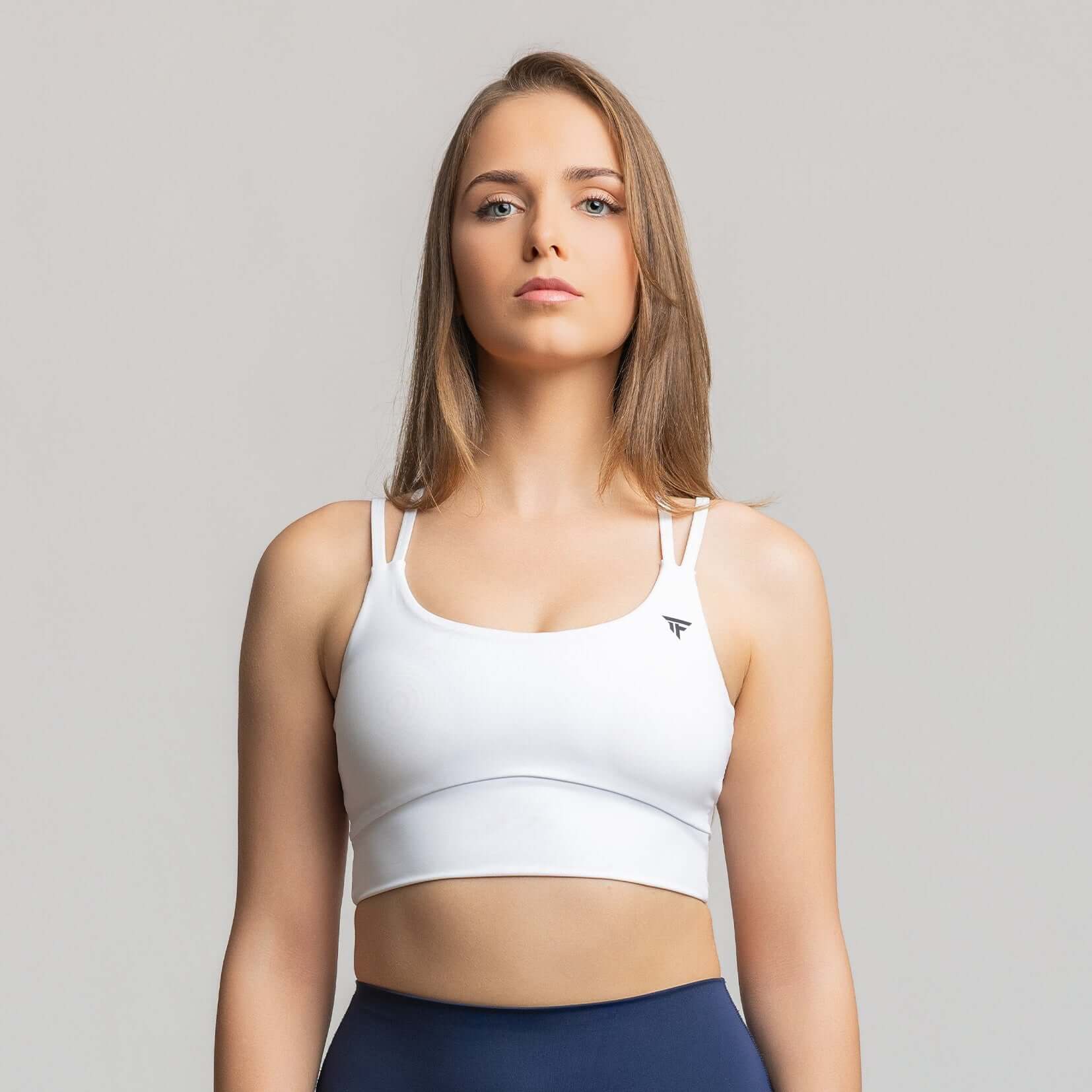 Criss cross back sports bra in white on a model, showcasing criss-cross back design for dynamic support.
