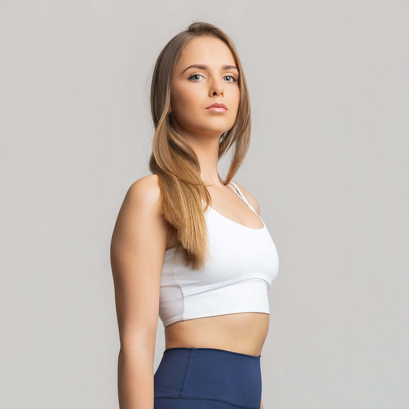 Criss cross back sports bra showcased by a model, highlighting its dynamic design and comfort.