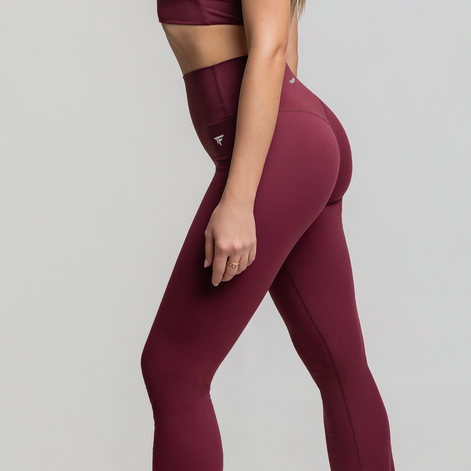 Three-quarter view of Dark Plum Flare Leggings showcasing contour-enhancing waistband