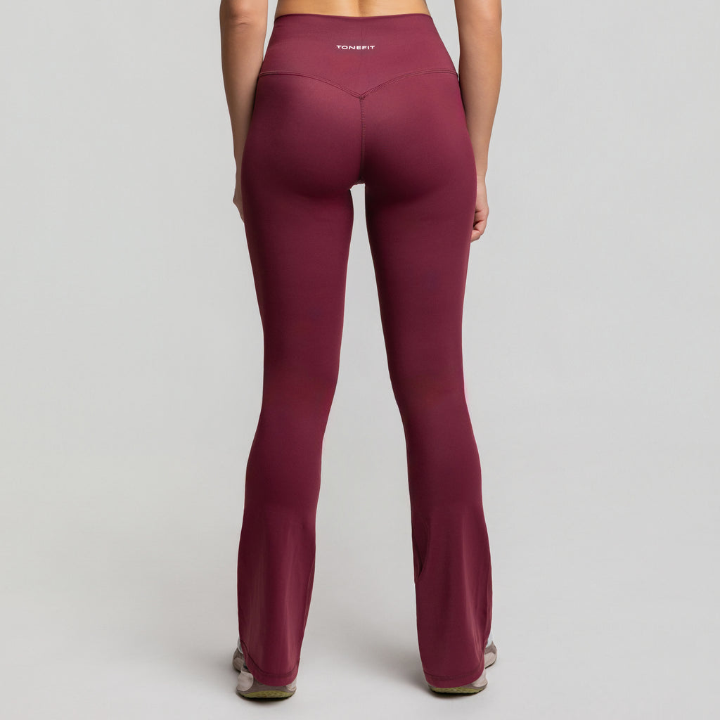 Back view of TONEFIT Flare Leggings in Dark Plum emphasizing flattering rear seam