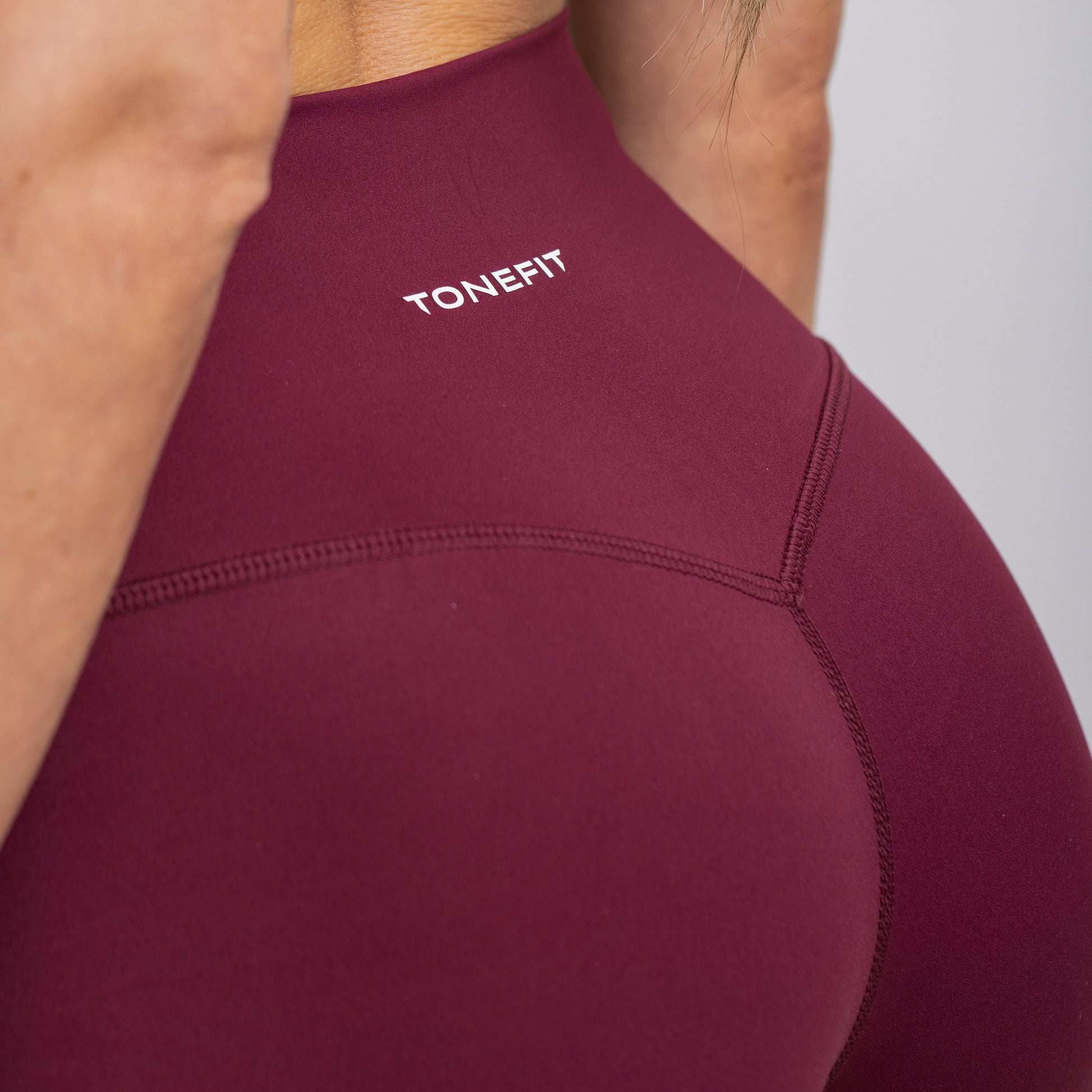 Close-up back view of Dark Plum Flare Leggings focusing on sculpting waistband and fabric texture
