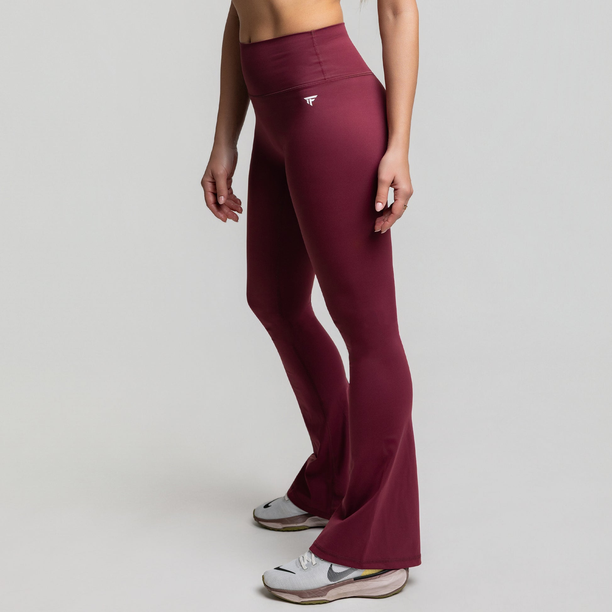 Angled front view of Dark Plum Flare Leggings highlighting sculpting waist and flare silhouette