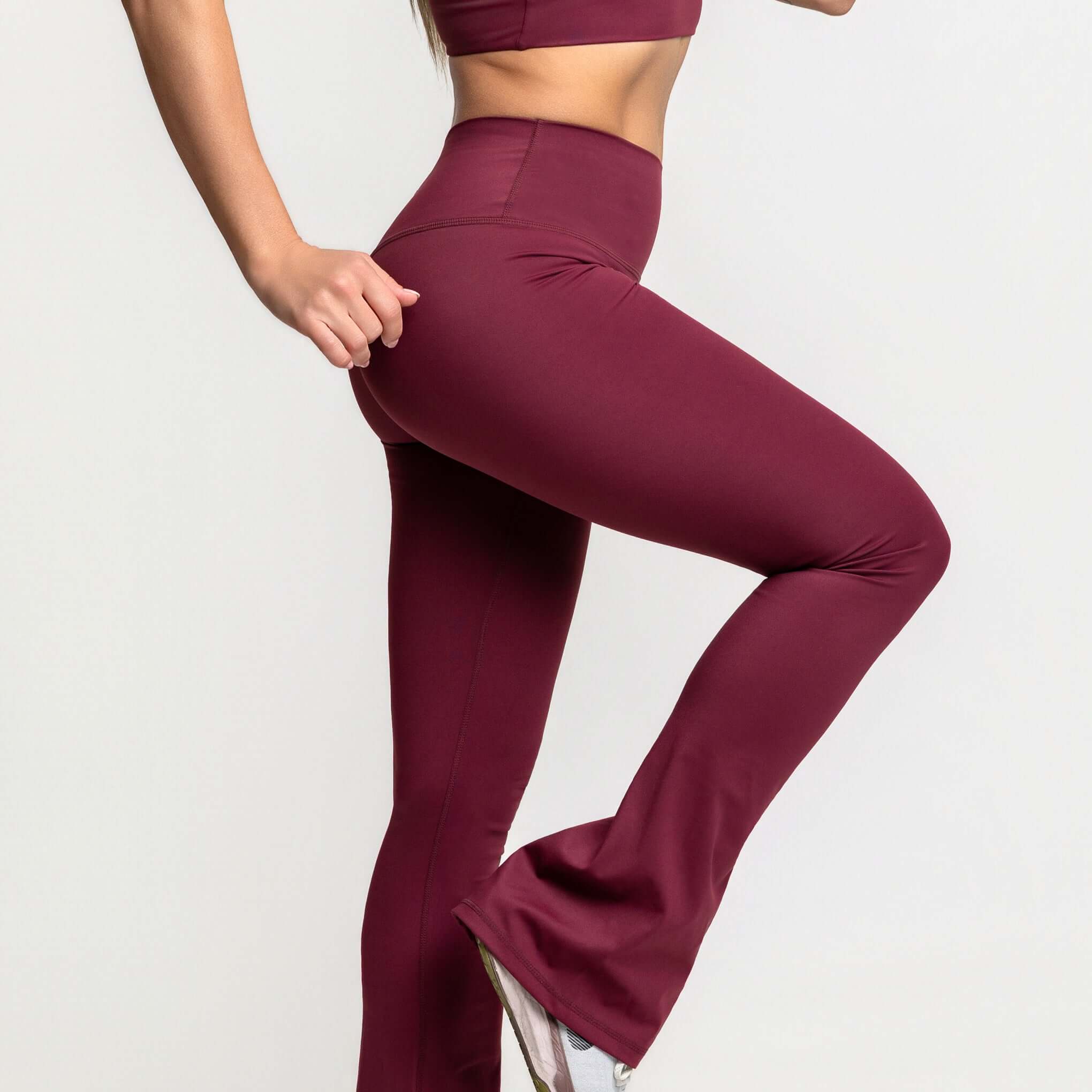 High waisted flare leggings in burgundy, featuring a fitted waist and flared hem for a stylish workout look.