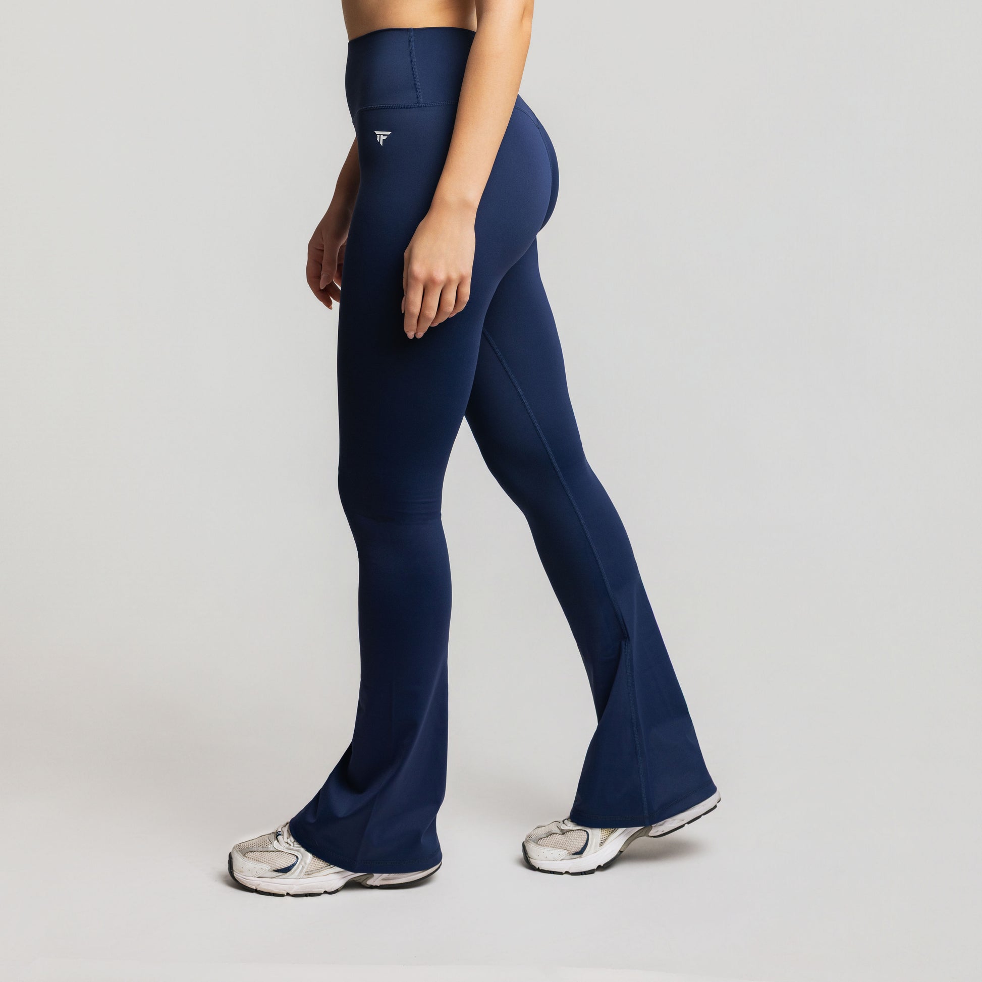 Person wearing navy blue leggings on a light gray background