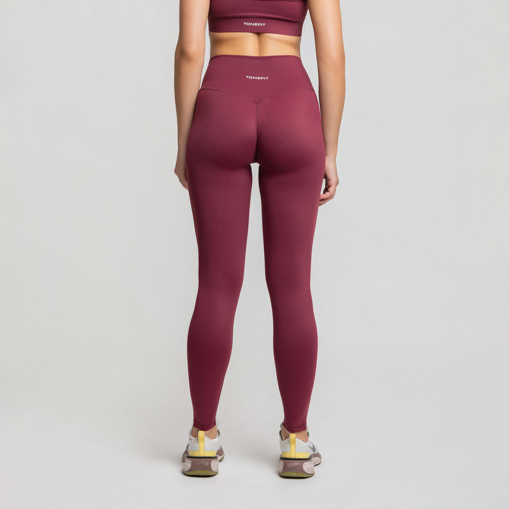 Back view of TONEFIT V-Waist Sculpt Leggings in Dark Plum featuring curved seam for sculpted shape