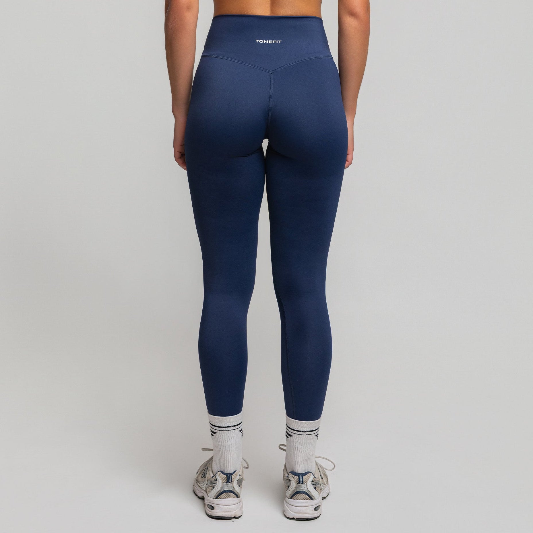 Back view of Deep Sapphire V-Waist Sculpt Leggings featuring TONEFIT logo and curve-enhancing seams