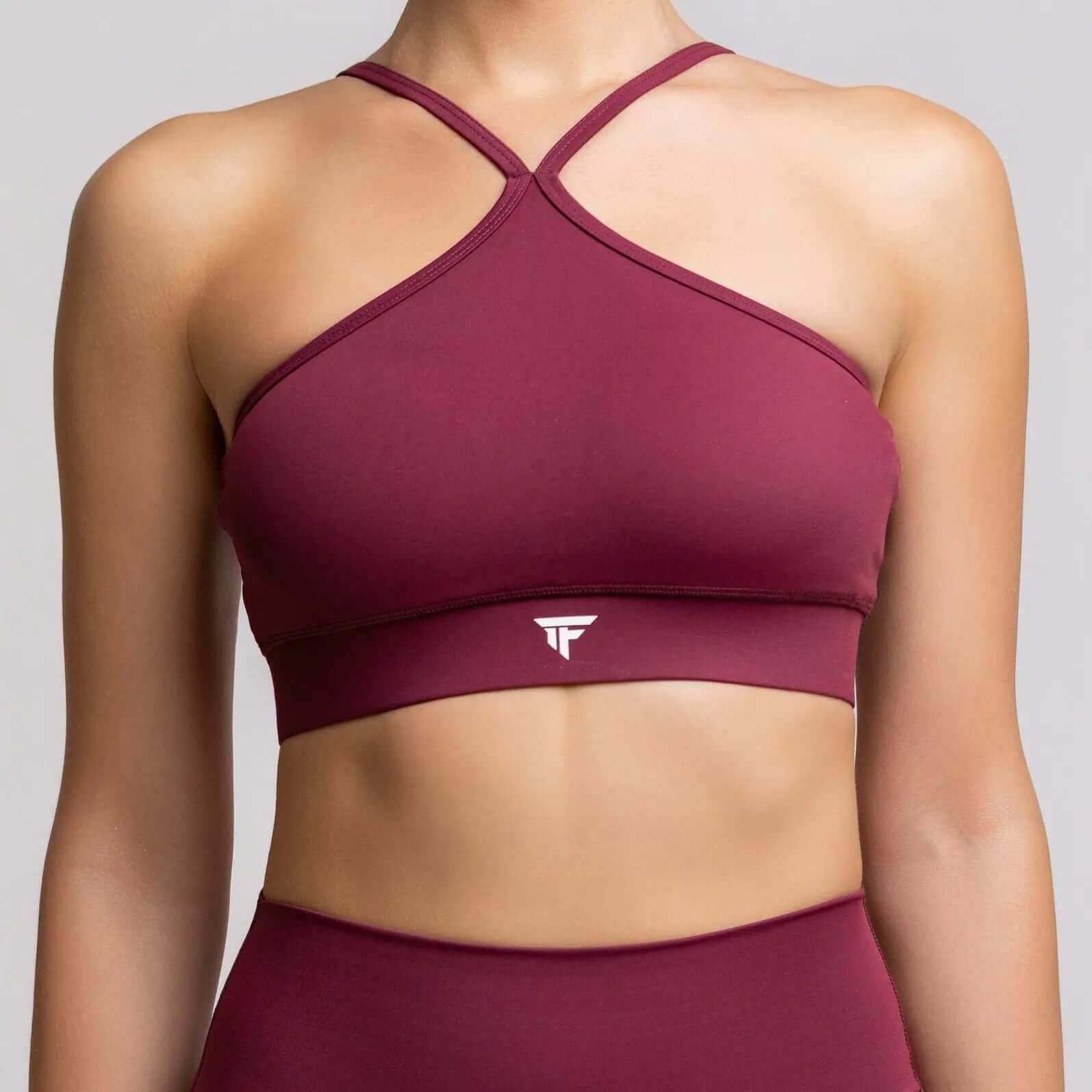 Halter neck sports bra in burgundy color with a stylish cross-back design for athletic performance.