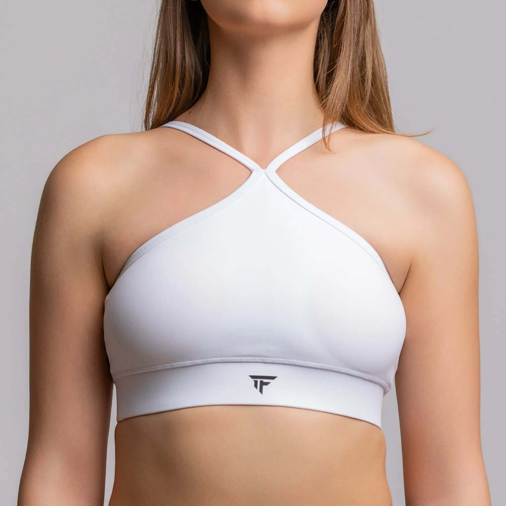 Halter neck sports bra in white, designed for performance and support, perfect for studio practice.