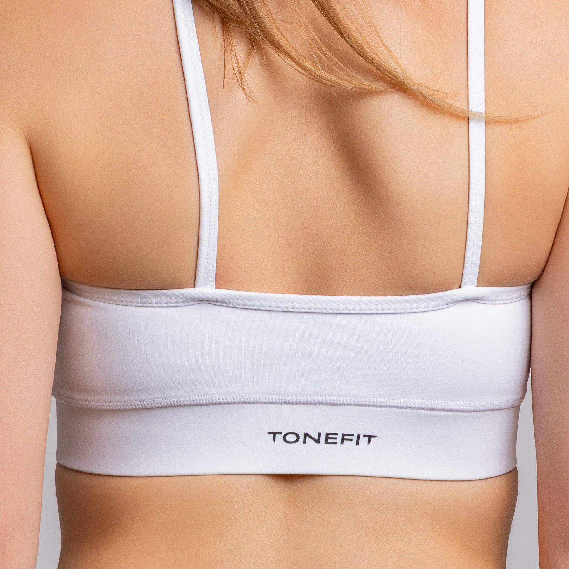 TONEFIT halter crop bra in white – side close-up view highlighting shoulder strap and fit