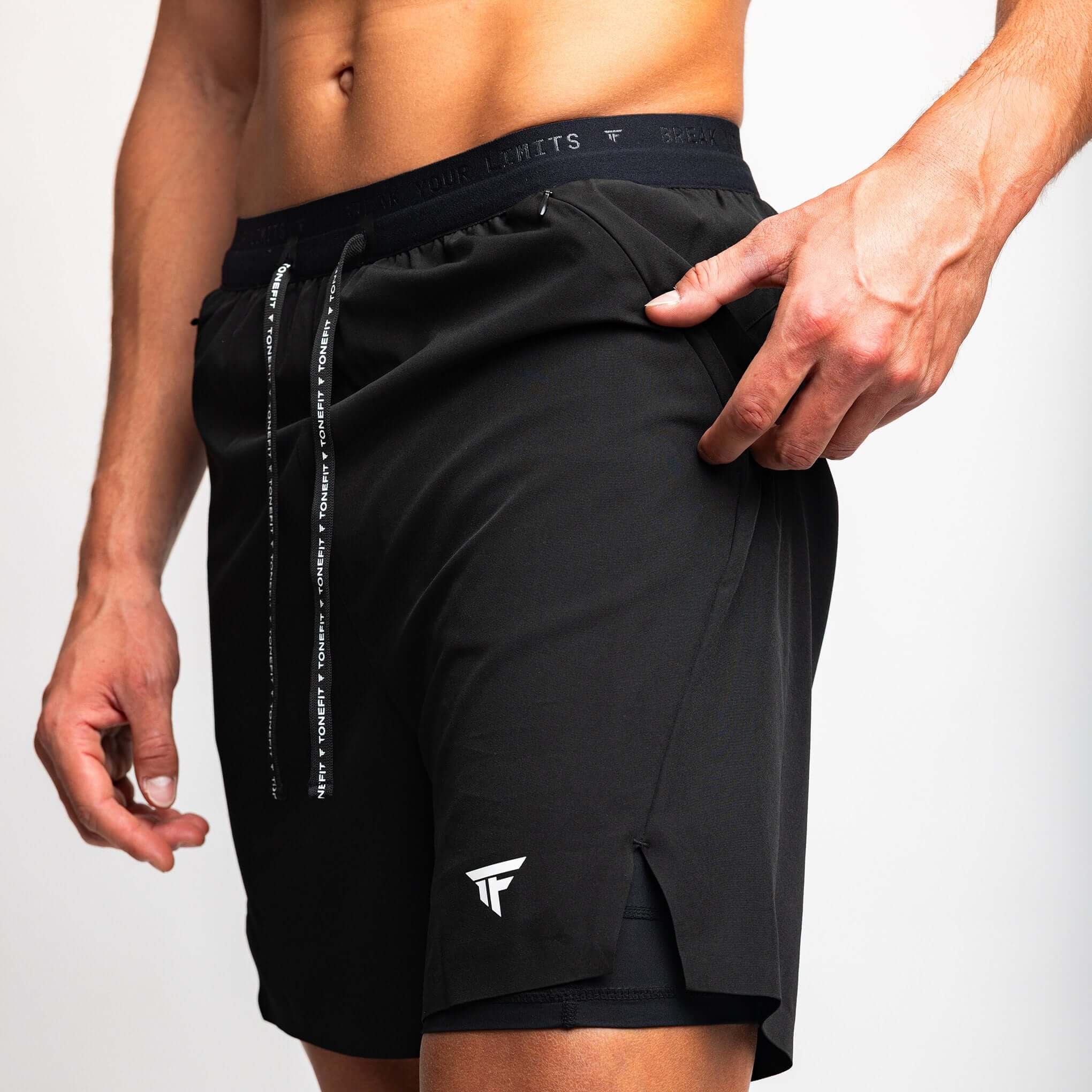 Close-up of a man wearing 2-in-1 hybrid training shorts, showcasing the design and fit of The Circuit shorts by TONEFIT.