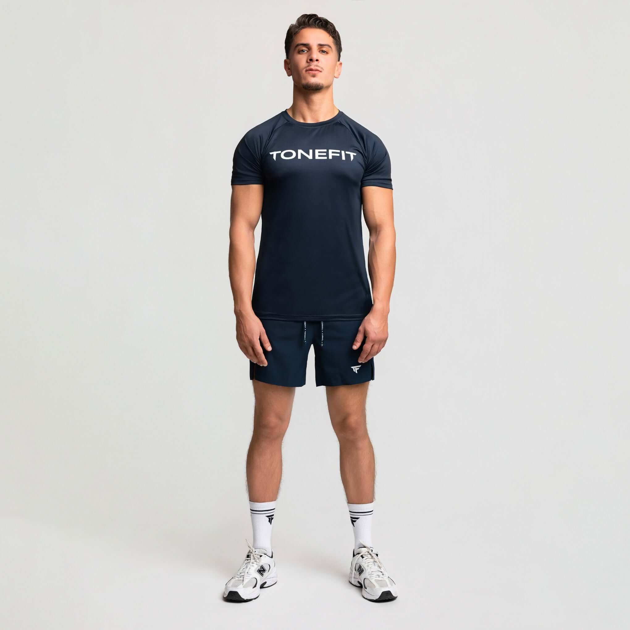 Model wearing TONEFIT 2-in-1 hybrid training shorts and matching shirt, ideal for modern athletes.