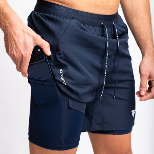 Close-up of TONEFIT men's navy shorts with built-in phone pocket and compression layer 